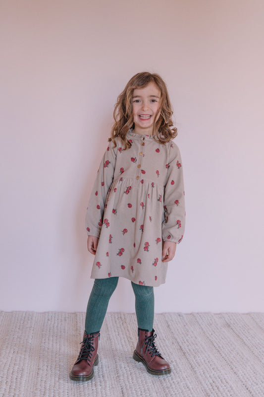 Kind draagt Studio Bohème Vermont kinderjurk met lange mouwen en houten knoopjes